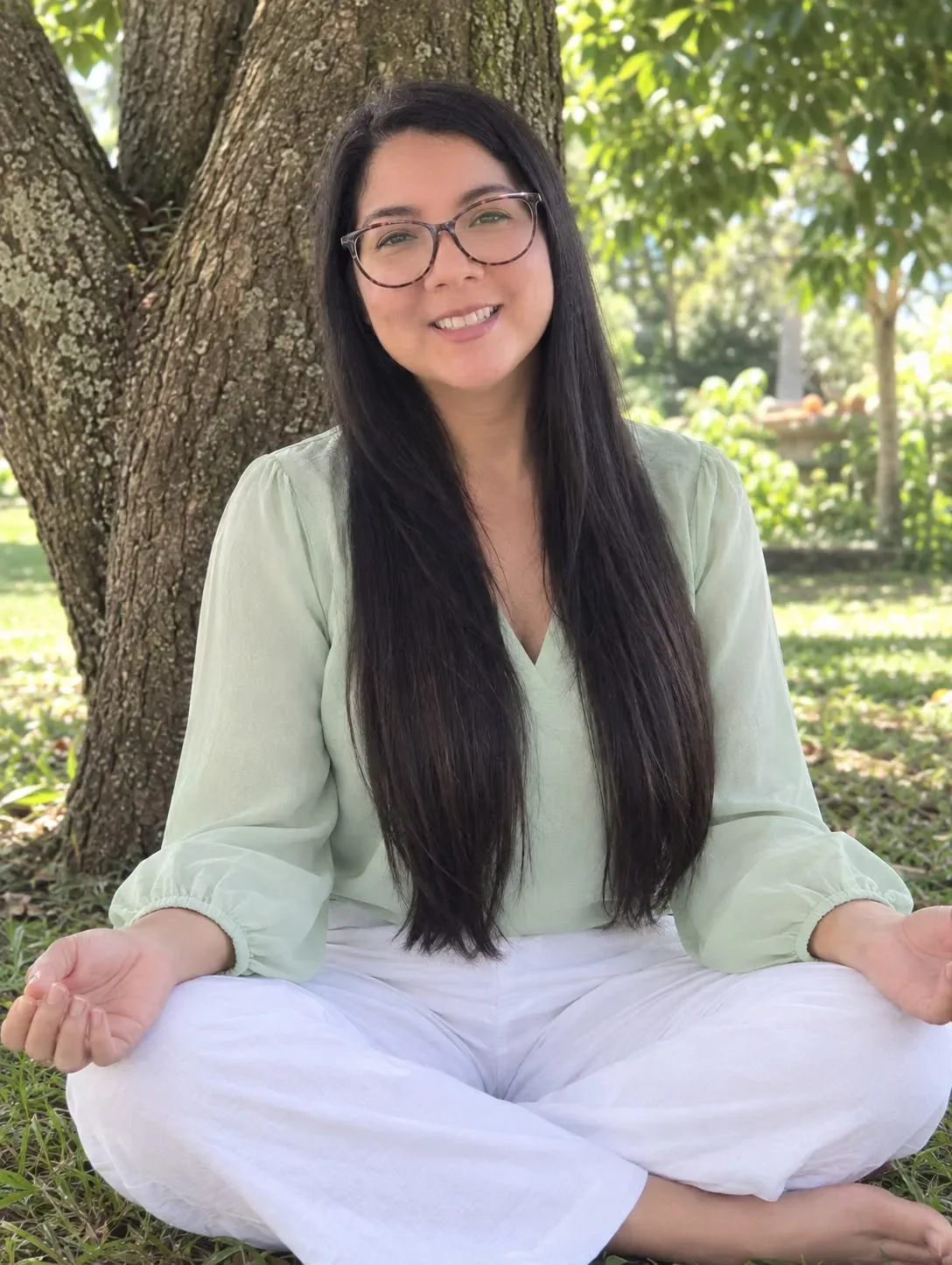 Vielka Loor, terapeuta holística, meditando bajo un árbol